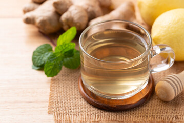 Lemon and ginger tea in cup glass on wooden background, Healthy hot drink