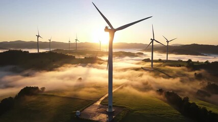 Breathtaking sunrise over a wind farm with turbines generating clean energy amidst a sea of fog creating a serene and environmentally conscious landscape at dawn
