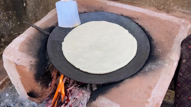 Corn Flatbread Cooking on Wooden Stove in Traditional Village Kitchen