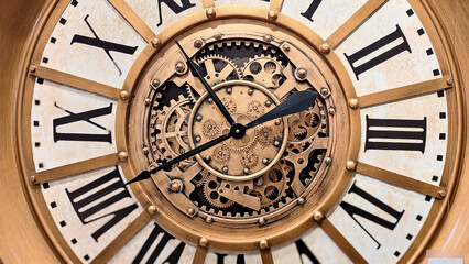 A large, open-faced wall clock with a distressed gold-wash metal finish and exposed, moving 3D gears. Close up of elegant Antique clock featuring roman numerals, classic design.