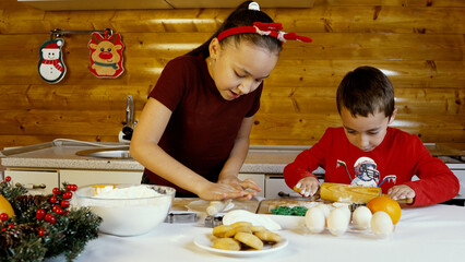 The children are baking and decorating Christmas cookies in the kitchen
