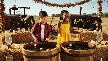 Children Playing Apple Bobbing Game in Barrels on Farm with Vintage Tractors at Fall Harvest Festival Celebration Sunny Day Two Kids in Red and Yellow Clothes Enjoying Autumn Activity