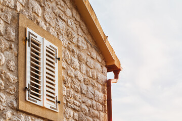Stone wall of house with shutters
