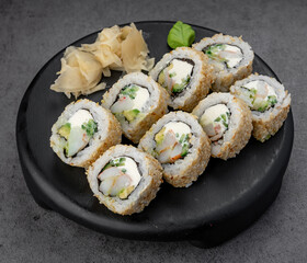 Sesame uramaki with shrimp and cheese. Inside out sesame rolls hide shrimp, avocado, and cream cheese with tidy studio plating.