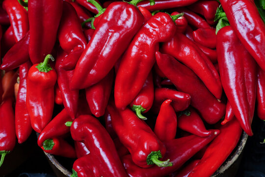 Fresh red chili peppers piled together at market stall - Powered by Adobe