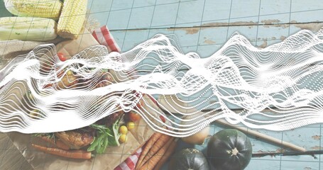 Displaying rustic spread with roasted bird, carrots, corn, tomatoes on blue planks, waveform