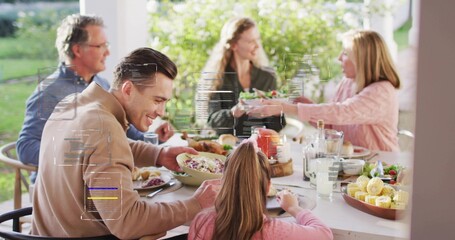 Smiling family group passing salad at covered patio table, man in tan jacket, AR overlays