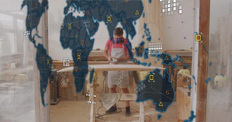 Sanding worker wearing respirator mask, apron using sander on board atop sawhorses with HUD overlay