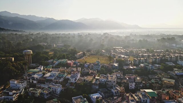 An aerial view of Dehradun, an Indian city during sunrise or sunset, with cloudy weather and rows of residential houses.
