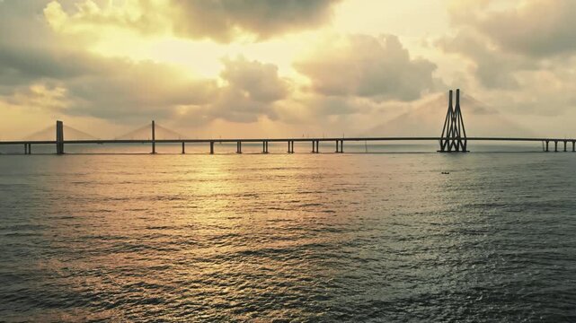 The stunning aerial view of the iconic Bandra-Worli Sea Link during the golden hour, with its dramatic clouds and the vast expanse of the sea in the background.
