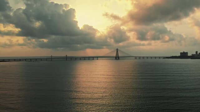 The stunning aerial view of the iconic Bandra-Worli Sea Link during the golden hour, with its dramatic clouds and the vast expanse of the sea in the background.