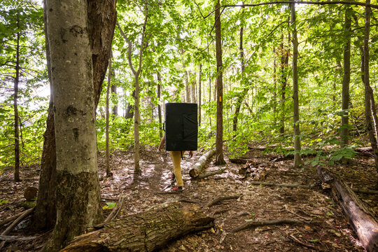 A rock climber walking a woodland trail with a bouldering pad
