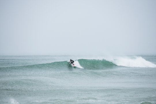 Solo man surfing during snow in winter
