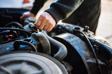 Man inspecting car engine in workshop