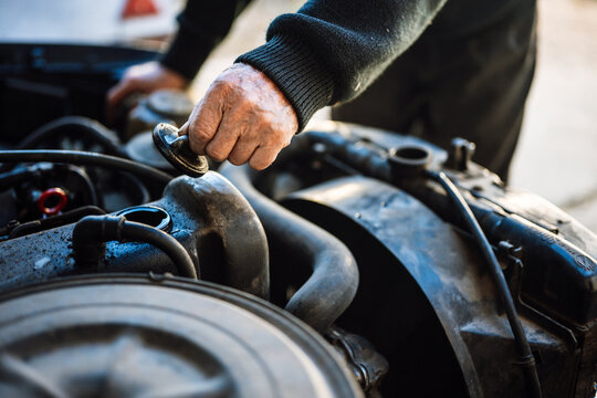 Man inspecting car engine in workshop