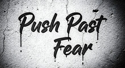 Inspirational graffiti art on a textured wall with the message 'Push Past Fear' encouraging courage and resilience