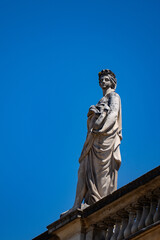 Fototapeta premium Classical Stone Goddess Statue with Lyre on the Roof of Grand Theatre under Clear Blue Sky in Bordeaux