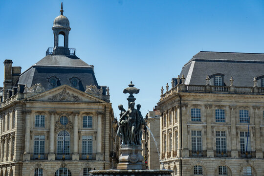 Close up of Three Graces Fountain between historic buildings at Place de la Bourse