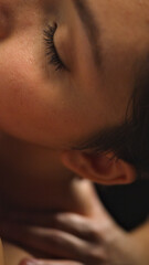 Close-up of a person receiving a facial massage, highlighting a serene expression and gentle touch. The setting suggests a spa or wellness center, emphasizing relaxation and rejuvenation.