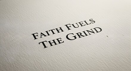 A close-up shot of a textured paper with the inspirational quote 'FAITH FUELS THE GRIND' printed in bold, black letters, emphasizing motivation and perseverance