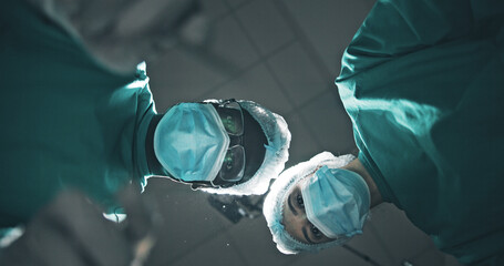 Below, doctor and people with portrait, surgery and surgical mask with emergency. Pov, group and employees in clinic, healthcare or medical service with face cover, procedure and treatment for injury