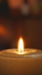 A close-up of a lit candle in a dim setting, symbolizing relaxation and self-care. The warm glow creates a serene atmosphere, ideal for meditation, spa treatments, or a calming ambiance.