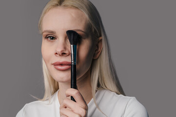 Closeup of woman demonstrating makeup application techniques