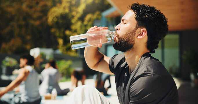 Drinking, outdoor and man with water at pilates class for break, relax or recovery on wellness retreat. Calm, rest and male person with healthy beverage for hydration at yoga session on holiday.