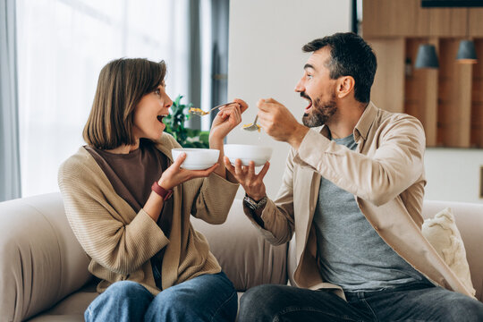 Happy couple enjoying playful breakfast at home