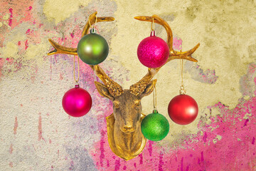 Golden deer head with Christmas baubles on vintage shabby chic wall