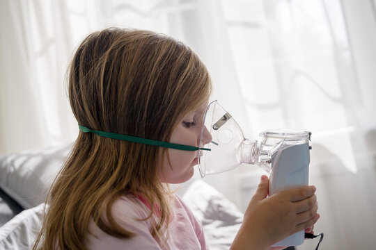 Child using nebuliser at home for respiratory illness treatment