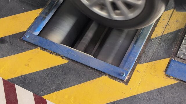 Spinning Car Wheel on Dyno Rollers in Workshop