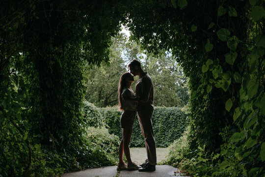 Romantic couple standing under plants in garden