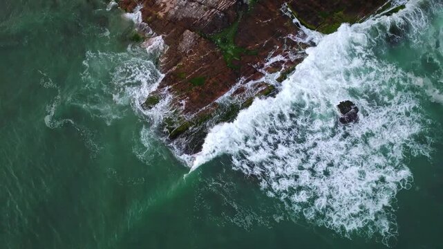 Dramatic aerial view of rocky coastline with crashing waves at Pai Kok Hei, Huizhou during sunset