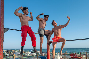 Three men doing calisthenics workout and taking selfie