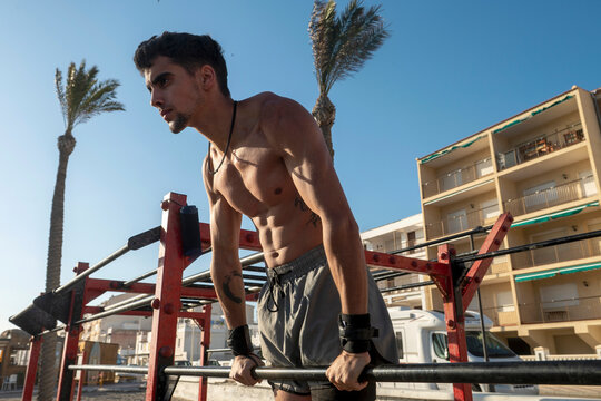 Man doing calisthenics workout at outdoor gym