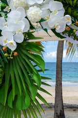 Bathed in sunlight, the wedding pagoda blooms with white orchids and silk, overlooking the turquoise Caribbean Se
