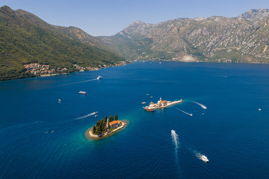 Aerial view of boats cutting through the deep blue waters around the islands of Sveti Dorde and Gospa od Skrpjela, Perast, Kotor Municipality, Montenegro.