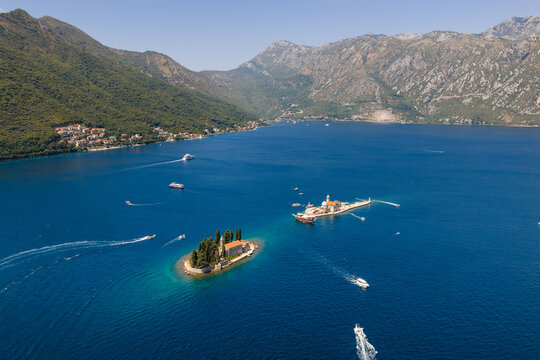 Aerial view of Sveti Dorde and Church of Our Lady of the Rocks islands glisten amidst the azure waters, cradled by majestic mountains, Perast, Kotor Municipality, Montenegro.