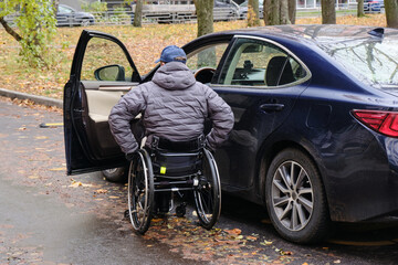 a man who uses a wheelchair approaches his car