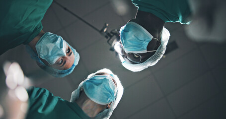 Below, people and doctors in theatre at hospital for surgery, medical procedure and critical...
