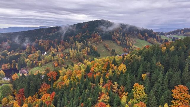 Mist drifting over peaceful countryside scenes, Drone captures vibrant fall foliage and quaint village settings