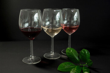 Row of three wine glasses on black background