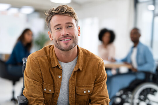 Smiling caucasian male in wheelchair at office meeting with colleagues - Powered by Adobe
