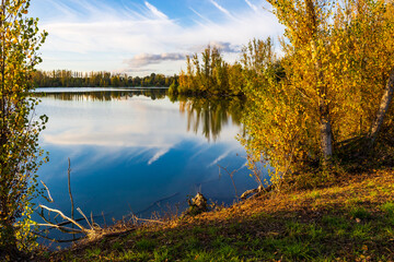Fototapeta premium Reflections of autumn-colored trees on the calm waters of Lake Sabatouse in Longages