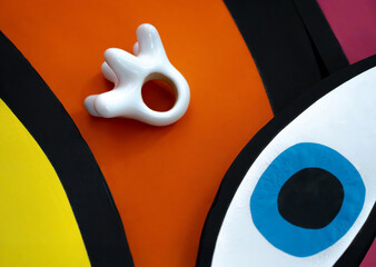 Abstract colorful composition with ceramic white ring on bright orange, yellow, blue and black background — modern pop art minimalism with playful shapes and bold color contrast