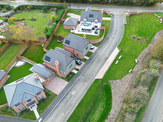 Aerial view of newly completed, detached executive homes and gardens seen on once brownfield site in rural Essex, UK. Note the newly laid lawns are Tudor designed homes.
