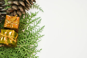 A christmas decoration with gifts pine cone and green leaves on a white background for the holidays
