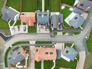Abstract, top down view of newly completed detached and semi detached houses sene on a British housing development site. Note the newly laid lush lawns.