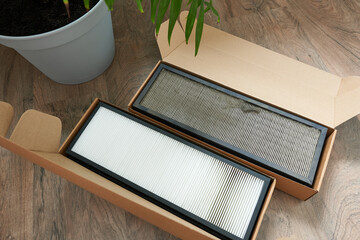 Air filter in cardboard box on wooden table, top view. Space for text